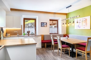 Eine moderne Küche mit Holzarbeitsplatten, einer integrierten Spüle und einem Essbereich mit Holztisch und roten Sitzgelegenheiten.