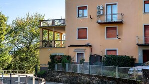 A multi-story building with balconies, air conditioning units, and a gated entrance. - Apartment 'La Terrazza' with Mountain View, Wi-Fi and Air Conditioning (Nesina)