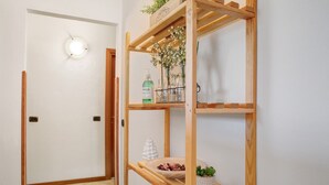 A hallway with a wooden shelf unit holding various items, a white door, and a light fixture. - Apartment 'La Terrazza' with Mountain View, Wi-Fi and Air Conditioning (Nesina)