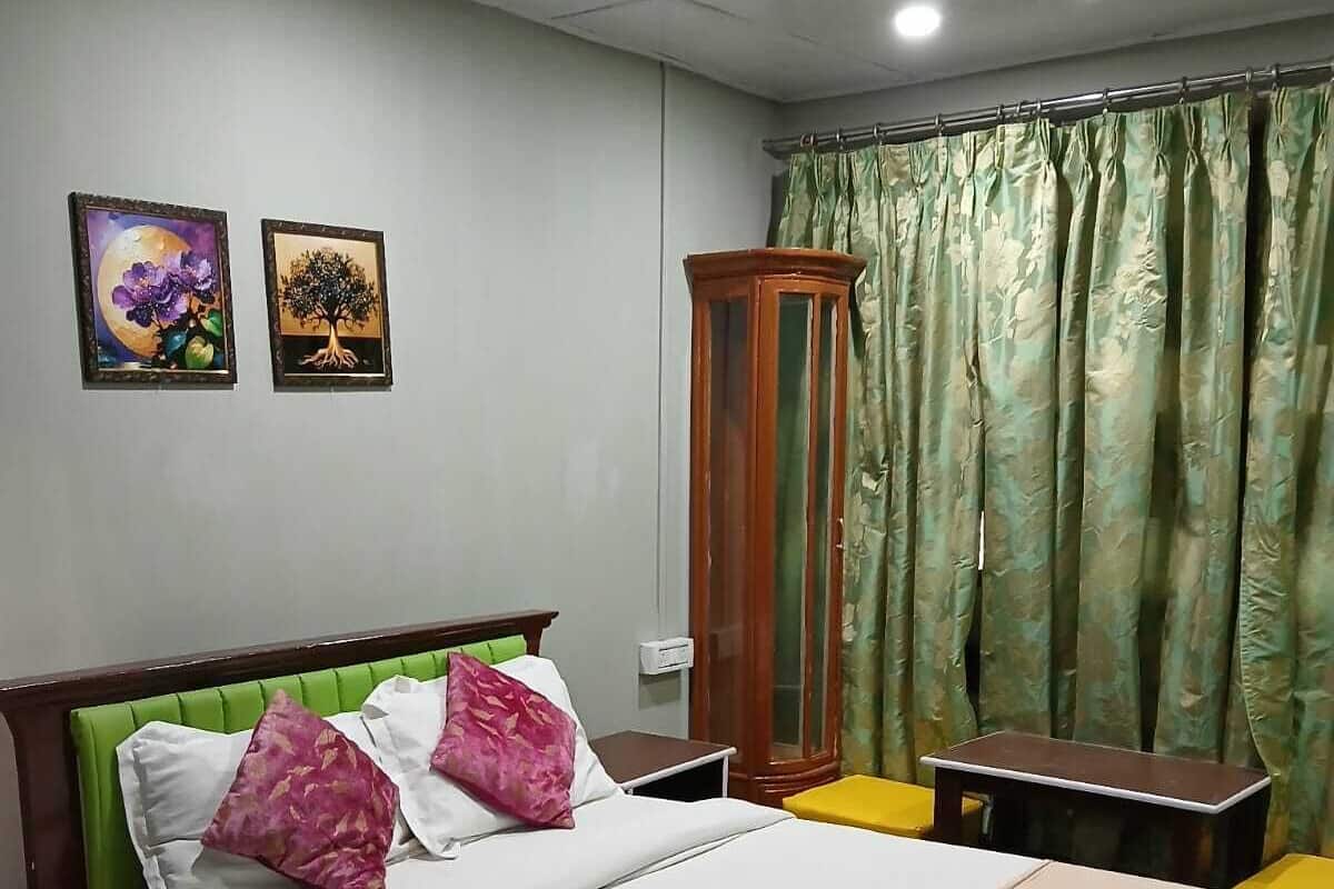 Un dormitorio ordenado con una cama, dos mesitas de noche, un armario y dos cuadros en la pared.