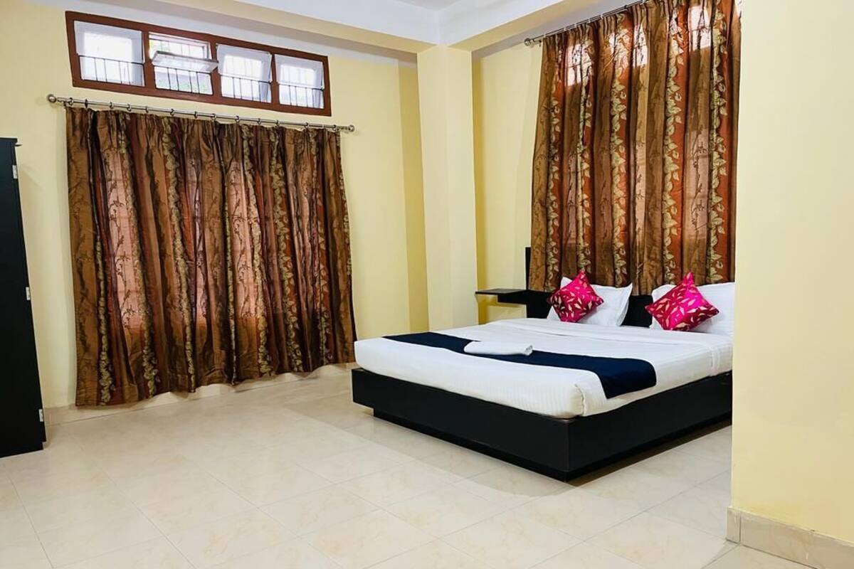 Un dormitorio con cama, cortinas y ventana.