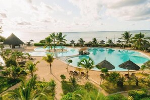 A resort with multiple swimming pools, palm trees, and a beach view. - The One Resort Zanzibar (Kusini)