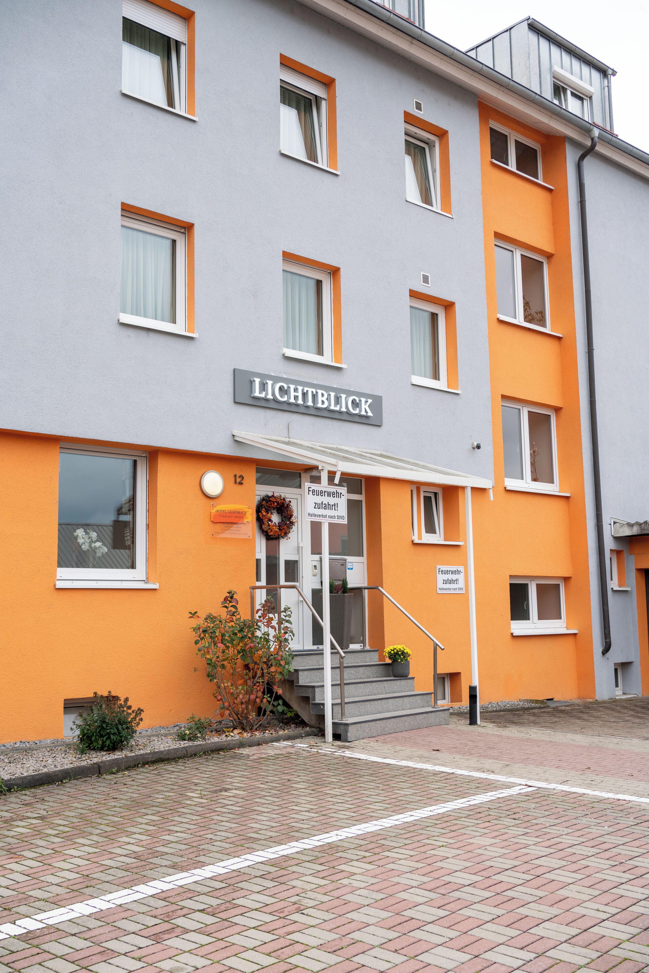Um hotel com vários andares, com uma placa indicando 'LICHTBLICK' e um sinal de segurança contra incêndio.