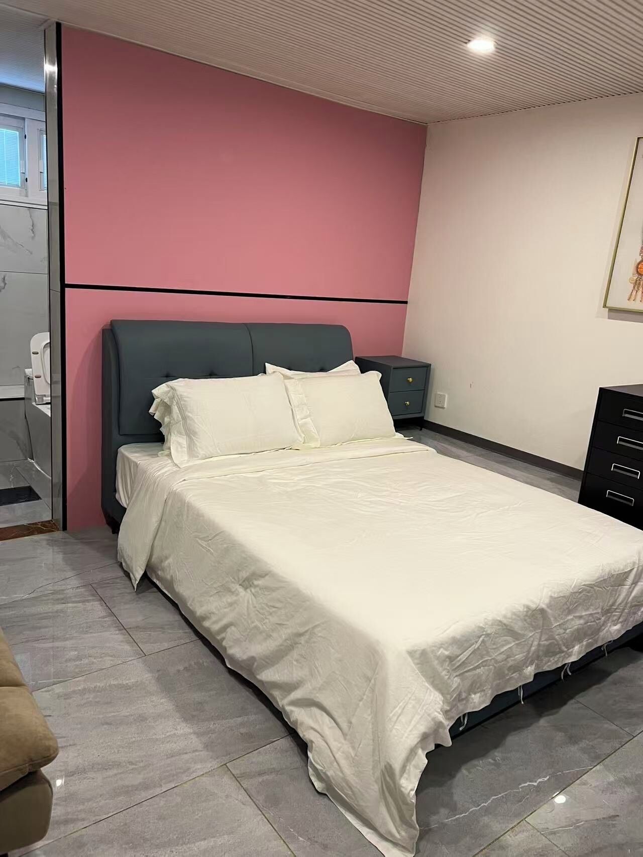 Un dormitorio moderno con cama, mesita de noche y cómoda.