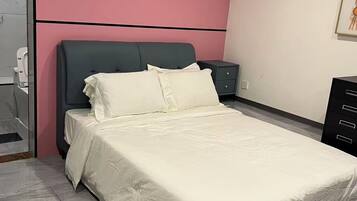 Un dormitorio moderno con cama, mesita de noche y cómoda.