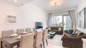 A modern living room with a dining area, a sofa set, and a TV.
