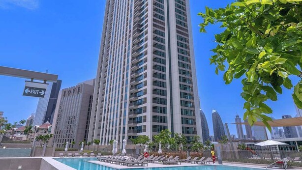 A high-rise building with a swimming pool in the foreground.