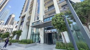 Un immeuble moderne de grande hauteur, doté d’une entrée imposante et d’une enseigne indiquant « CREEKSIDE ».