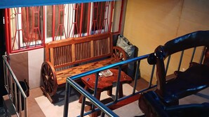 A room with a wooden bench, a small table, and a metal railing. - Comfortable Stay in Baguio City (Baguio)