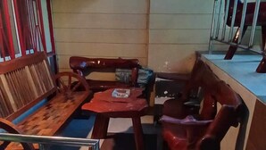 A room with a wooden bench, a small table, and a stool. - Comfortable Stay in Baguio City (Baguio)