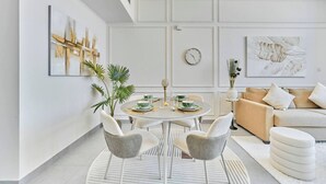Un salon moderne avec une table de salle à manger ronde, deux chaises, un canapé et une table basse.