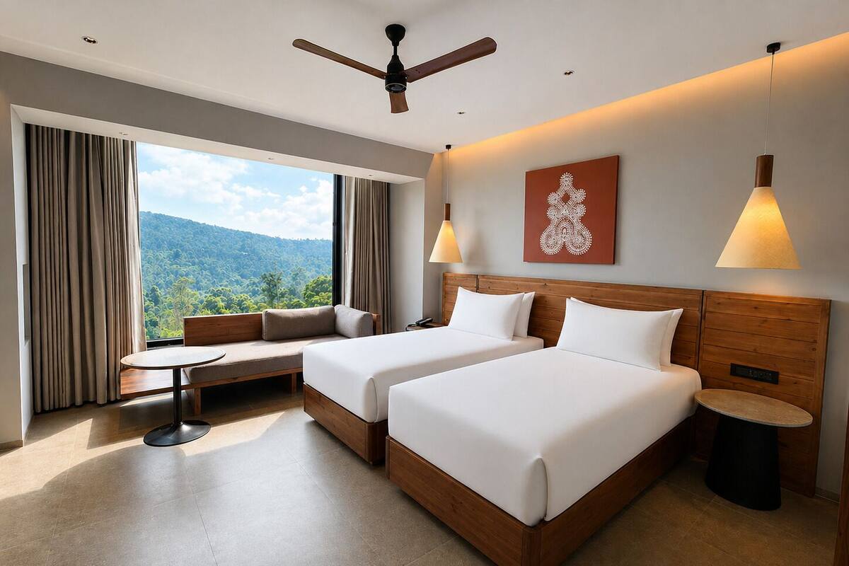 A hotel room with two beds, a sofa, a table, and a view of the outdoors.