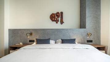 A modern bedroom with a large bed, two bedside tables, and a unique wall art piece.