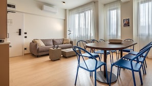 Un salon moderne comprenant un canapé, une table basse et une table à manger avec des chaises.