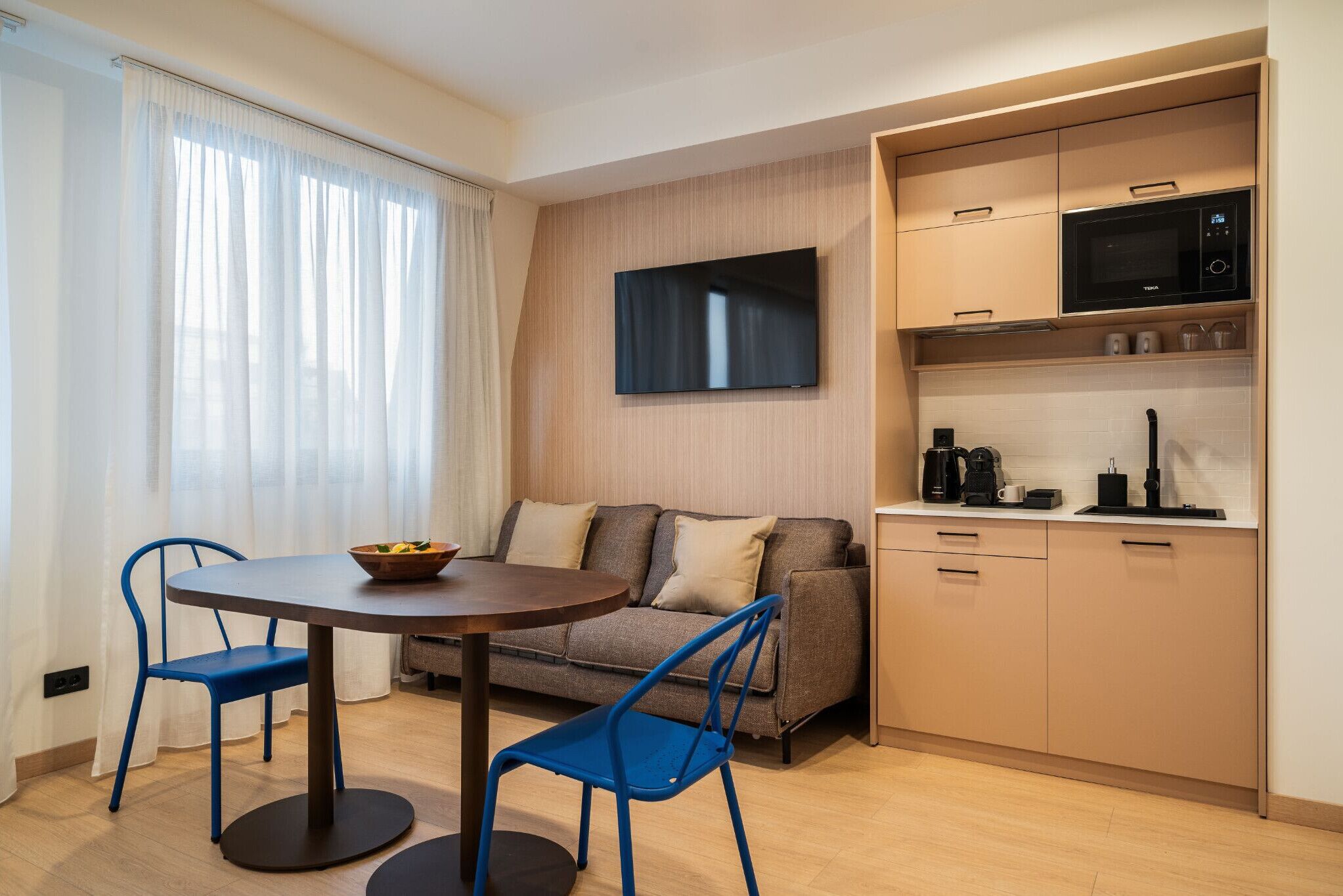Ein stilvoller Wohnbereich mit Essplatz, Sofa und Küchenzeile.