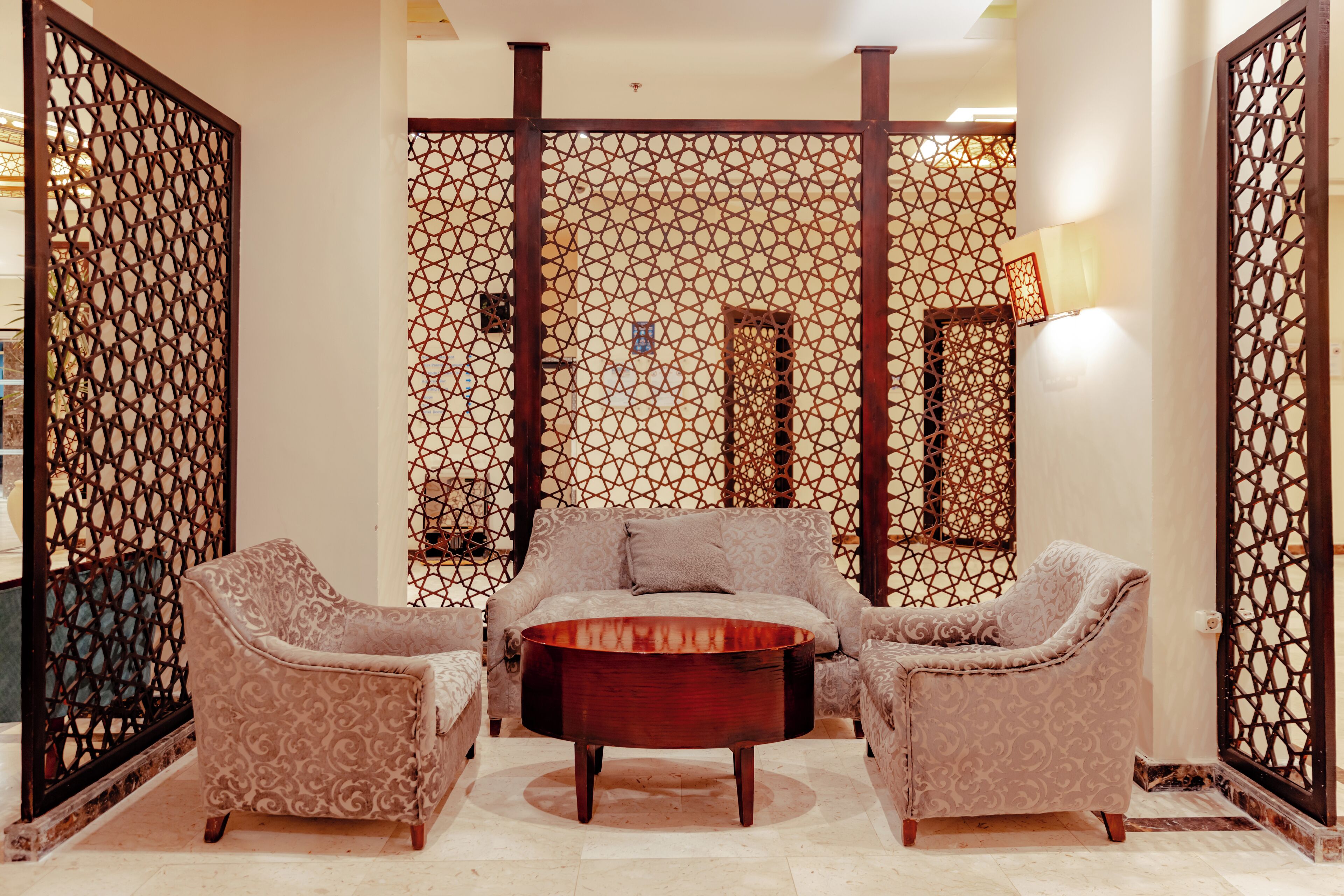 A room with a sofa set, a coffee table, and a decorative screen.