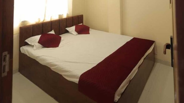 Un dormitorio con cama, cortinas, ventilador de techo e iluminación.