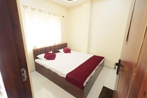 Une chambre à coucher avec un lit, des rideaux et une porte en bois.