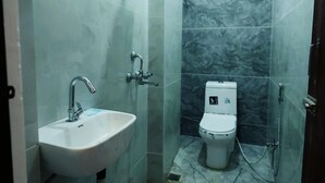 Un baño con lavamanos, inodoro y ducha.