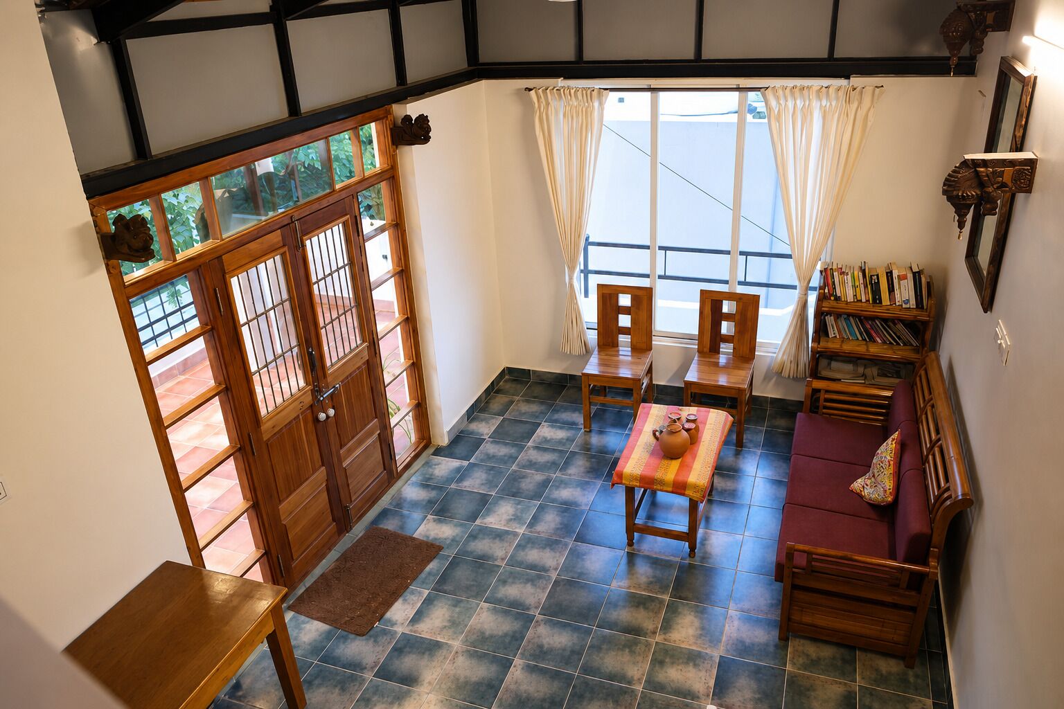 A traditional Japanese-style room with tatami flooring, a low table with a tea set, and a sofa.