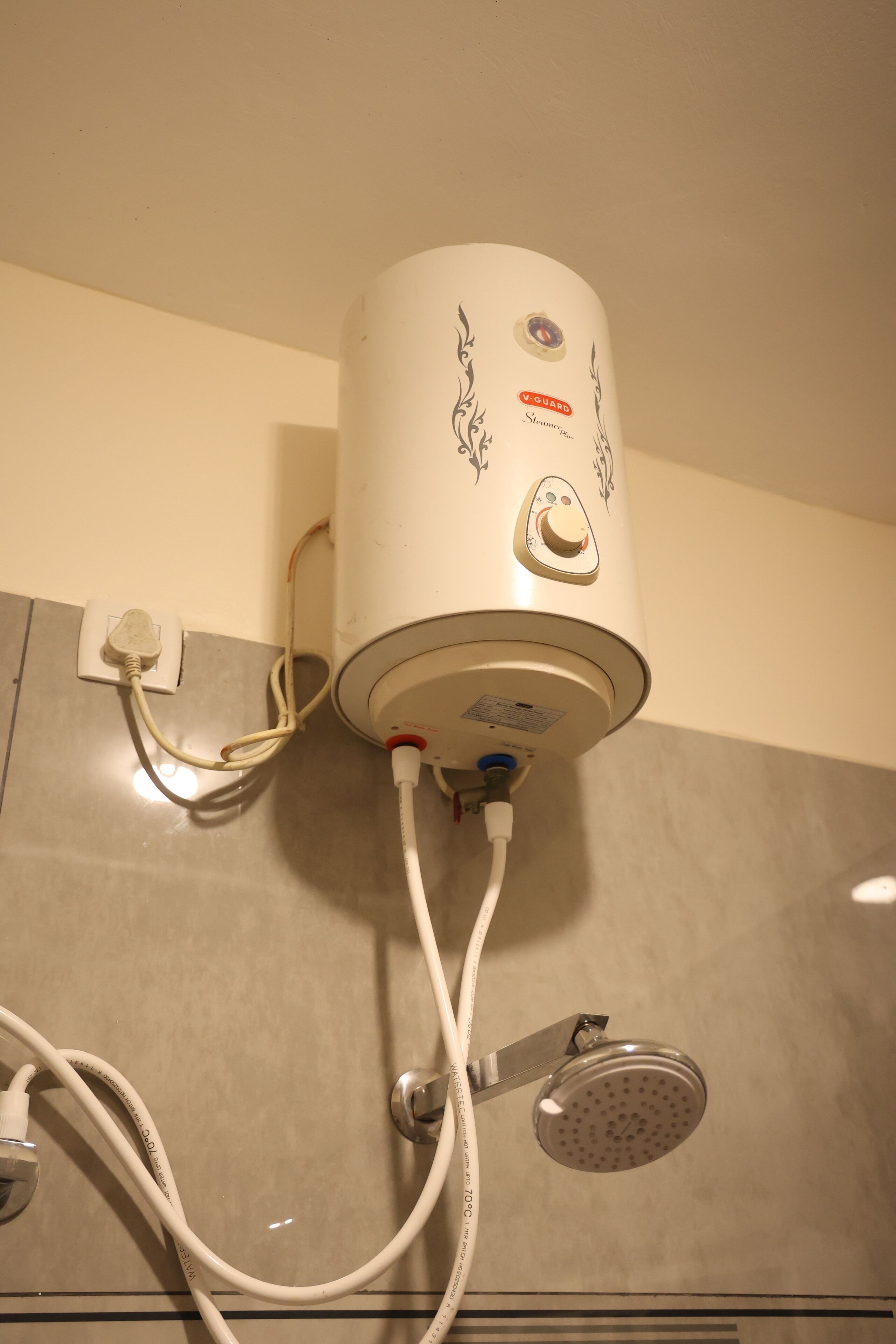 Un radiateur portatif blanc, doté d’un panneau de commande et d’un câble d’alimentation branché à une prise murale.