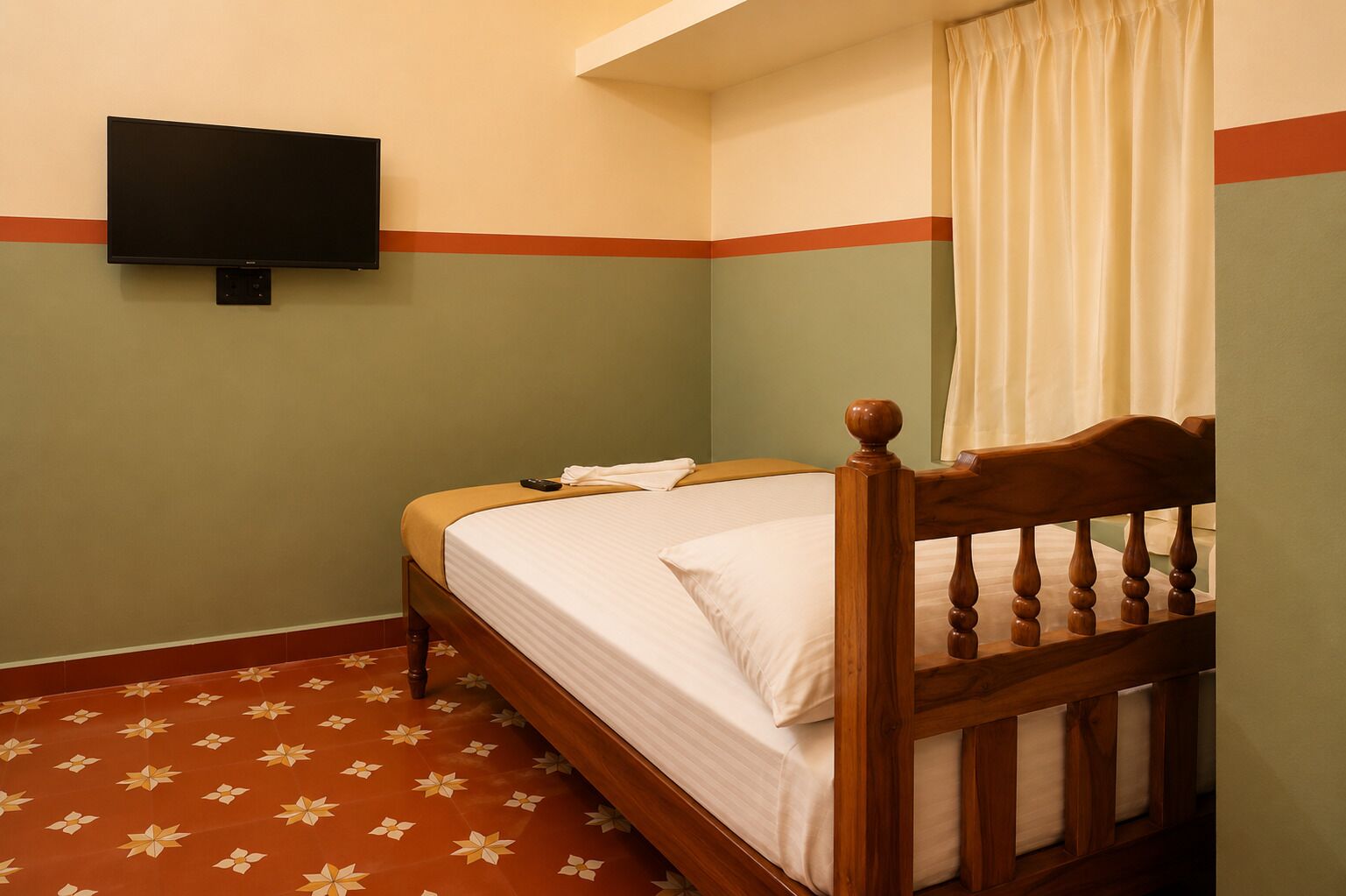 A single bed with a wooden headboard, a flat-screen TV mounted on the wall, and a patterned floor.