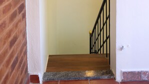 Eine Treppe mit Handlauf, einer Wandleuchte und einem dekorativen Wandbild.