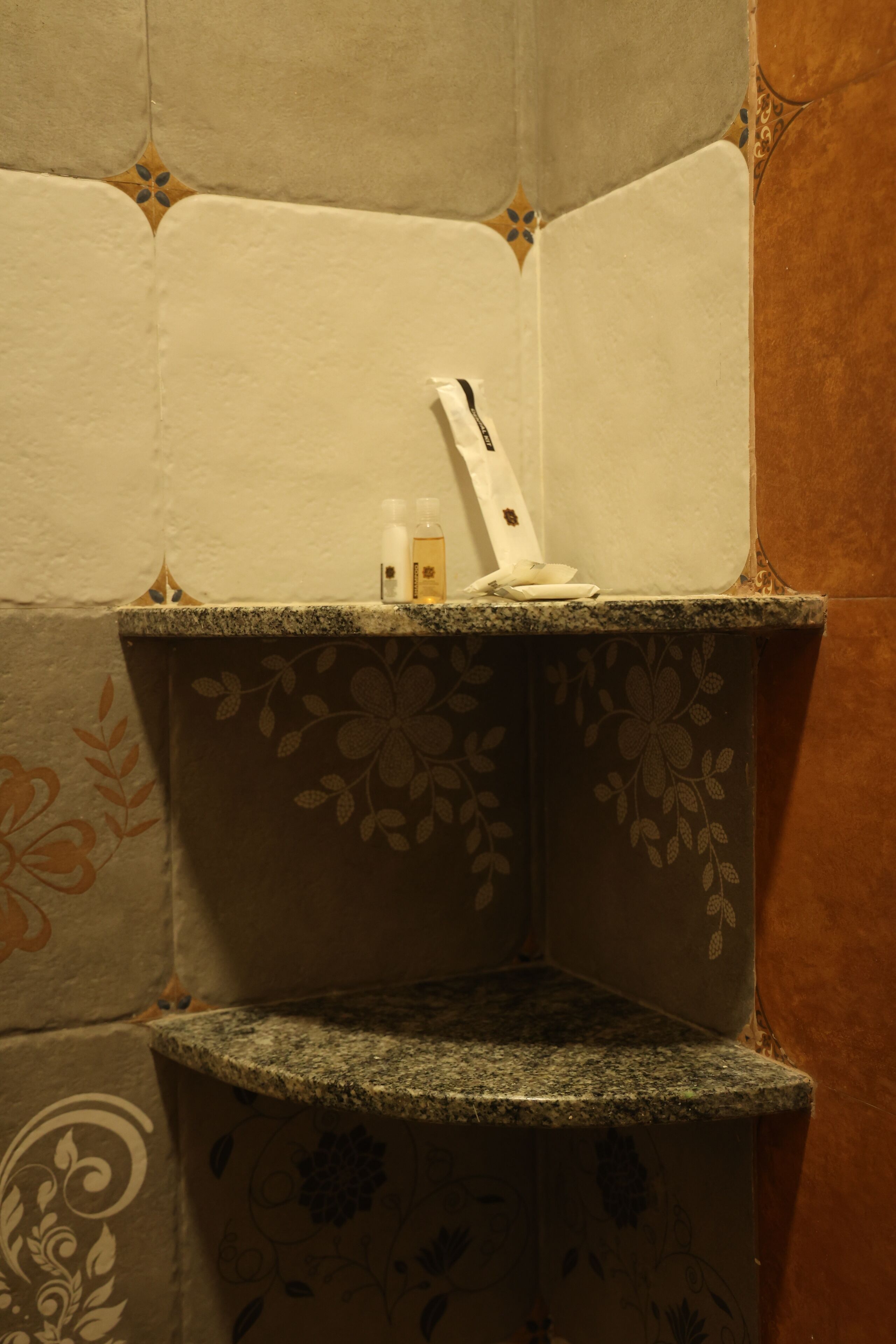 A corner with a granite countertop, a white towel, and two bottles of lotion.