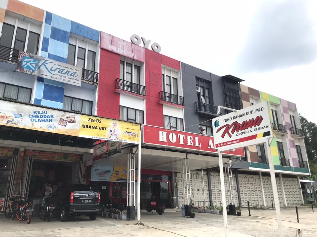 A multi-story building with a prominent red sign for a hotel named "Hotel A".
