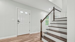 Una escalera con escalones de madera y barandilla blanca que conduce a una plataforma.
