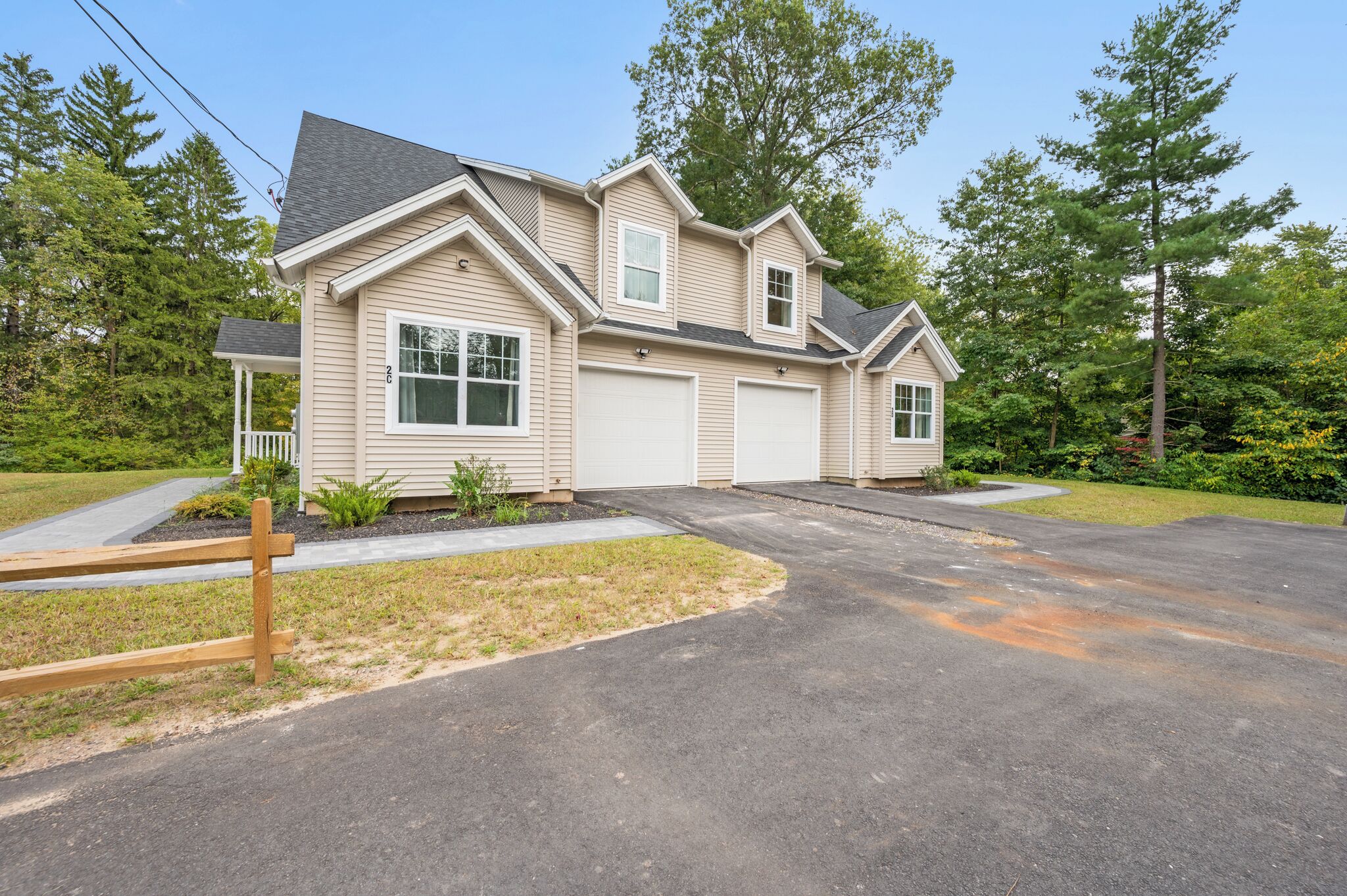 A two-story house with a garage, a covered porch, and a driveway.