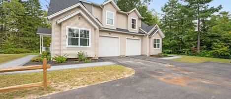 A two-story house with a garage, a covered porch, and a driveway.