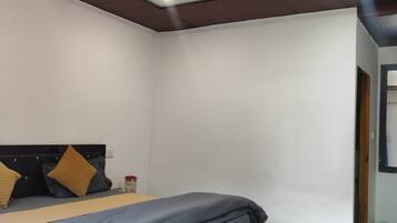 Une chambre à coucher avec un lit, un ventilateur de plafond et un sol carrelé.