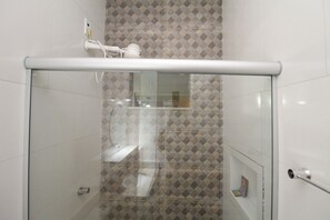 A glass-enclosed shower with a white ceiling and patterned tiles. - Casa Brisa do Bosque (Belém)