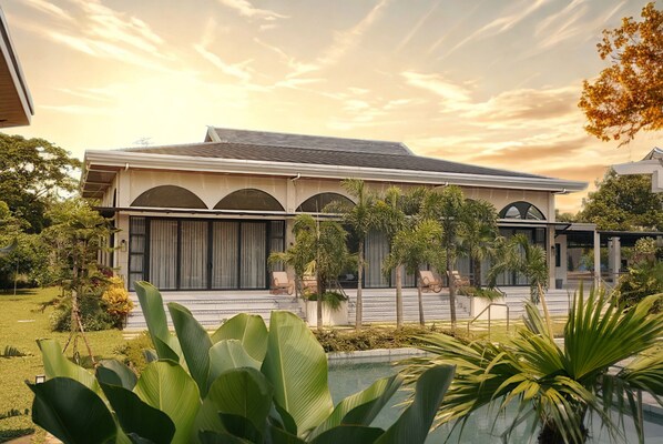A modern house with a large front lawn, a swimming pool, and a well-maintained garden. - La Manna Events and Leisure  (Tanauan City)