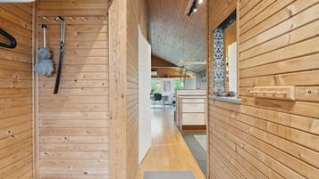 A wooden interior with a hallway leading to a kitchen area.