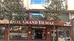 Um hotel chamado 'Grand Yilmaz', com fachada moderna, janelas amplas e entrada visível.