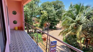 A balcony with a stone floor, a metal railing, and a sign advertising rooms for rent. - Saimata Residency (Gokarna)