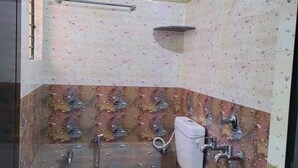A small bathroom with a toilet, shower, and sink. - Saimata Residency (Gokarna)