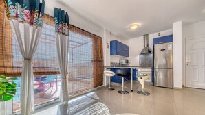 A modern kitchen with blue cabinets, a stainless steel refrigerator, and a microwave. - THE MERMAID HOUSE-PLAYA HONDA (Playa Honda)