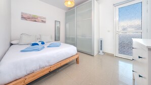 A bedroom with a bed, a wardrobe, a bedside table, a mirror, and a window with a view. - THE MERMAID HOUSE-PLAYA HONDA (Playa Honda)