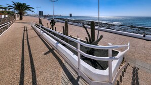 A coastal walkway with a white railing, cacti, and a clear view of the sea. - THE MERMAID HOUSE-PLAYA HONDA (Playa Honda)