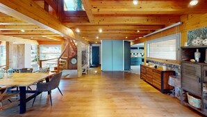 A spacious wooden interior with a dining area, kitchen, and staircase. - Family House Doussard (Lake Annecy) with swimming pool (Doussard)
