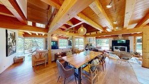A spacious wooden interior with a large dining table, comfortable seating, and a fireplace. - Family House Doussard (Lake Annecy) with swimming pool (Doussard)