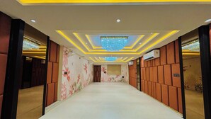 Un pasillo de diseño moderno, con una lámpara central, iluminación empotrada y un revestimiento de pared con diseño.
