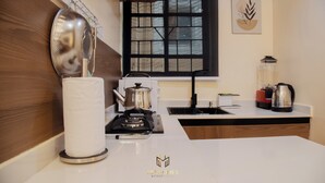 Une cuisine moderne équipée d’une cuisinière à gaz, d’une bouilloire, d’une machine à café et d’une fenêtre donnant sur un paysage agréable.