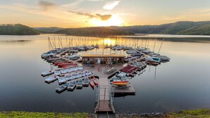 A marina with boats docked, a central building, and calm water. - Dormio Hotel der Seehof (Heimbach)