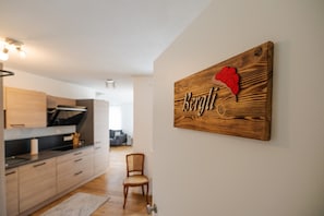 Une cuisine moderne avec des meubles en bois et un panneau mural décoratif en forme de cœur.