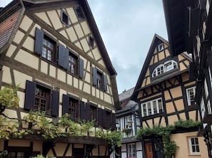 Un bâtiment traditionnel à colombages, doté de nombreuses fenêtres et d’un toit en pente.