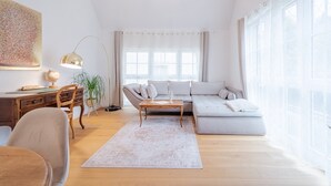 Un salon moderne comprenant un canapé, une table basse, un bureau et une lampe.
